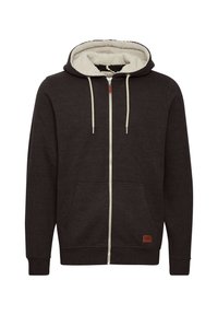 Donker antraciet rits hoodie met een zachte, crèmekleurige fleece binnenkant. Heeft een voorzak, een capuchon met trekkoord en een klein logopatch aan de onderkant.