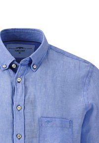 Camisa de lino azul claro con cuello abotonado, cinco botones en el frente y un bolsillo en el pecho. Textura suave con un ligero brillo.
