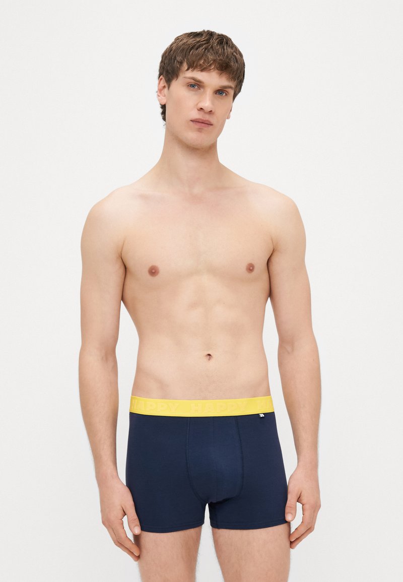Cuecas boxer azul-marinho com uma cintura elástica amarela com a palavra "HAPPY" impressa. Tecido macio e elástico com ajuste justo.