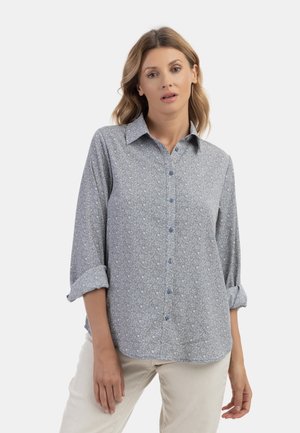Camicia azzurra chiaro con motivo floreale, maniche lunghe arrotolate, texture morbida e colletto classico.