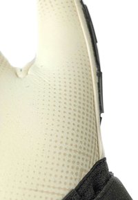 Schaumstoff in neutraler Farbe mit strukturierter Oberfläche, versehen mit kleinen Punkten und einem schwarzen Band. Das Design ist ergonomisch und hat eine markante Form.