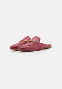 Zapatos de piel trenzada en color rosa, tipo slip-on, con un acento de cadena a lo largo del empeine. Cuentan con un puntera redondeada y un bajo tacón de madera. Suela plana.