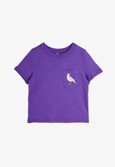 Lila t-shirt med kort ärm och bröstficka som har en broderad vit fågel. Mjuk tyg med en avslappnad och ledig passform.