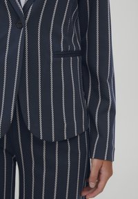 Mornar blue blazer s bijelim vertikalnim prugama, s jednim gumbom, džepom na prsima i glatkom teksturom.