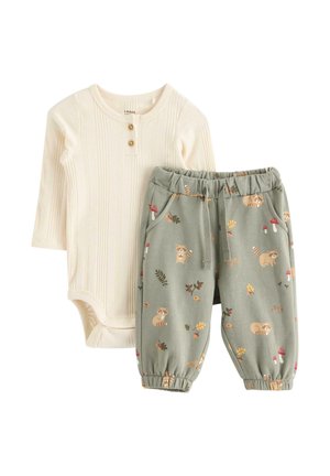 Cremafarbener, gerippter Baby-Body mit langen Ärmeln und Knöpfen, kombiniert mit grauen elastischen Hosen mit Waschbär-, Blatt- und Pilzmotiven.