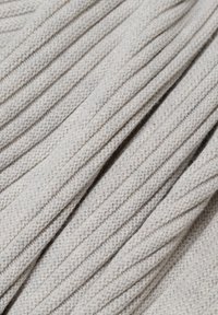 Hellgrauer Strickstoff mit einem gerippten Muster, das eine weiche Textur und gleichmäßige Nähte im gesamten Material aufweist.