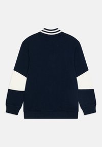Felpa della marina con colletto a righe bianche e maniche bianche a contrasto. Presenta polsini e orlo ribbed. Materiale liscio, vestibilità casual.