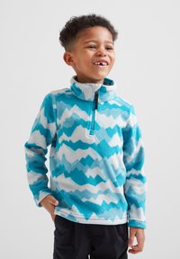 Light blue and white fleece pullover with zigzag pattern, high collar, and quarter-zip front, combined with black pants.
