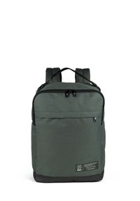 Mochila verde oscura con forma rectangular, detalles en cremallera negra y un bolsillo frontal. Fabricada con un tejido texturizado que lleva una etiqueta con el logo.
