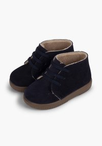 Stivali in suede blu navy con interno morbido, caratterizzati da punte rotonde, lacci frontali e suole in gomma per trazione e durata.
