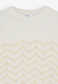 Cremefarvet sweater med et bølge mønster i en lysere nuance. Ribbet rund hals og blød tekstur. Brandmærke synligt inde i halsudskæringen.