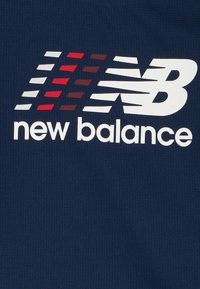 Granatowa tkanina o siatkowej fakturze z białym logo "NB" i stylizowanymi paskami w kolorach czerwonym, ciemnoczerwonym i białym nad napisem "new balance".