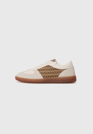 Beige low-top sneaker with light brown suede and patterned fabric side panel, rounded toe, white laces, and brown rubber sole.