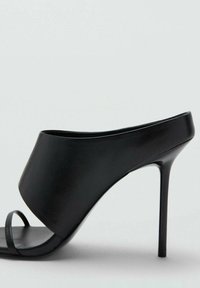 Sandalo nero con tacco alto, esterno in pelle liscia, design con punta aperta e ampia fascia sulla parte anteriore. Presenta un tacco sottile e affusolato.