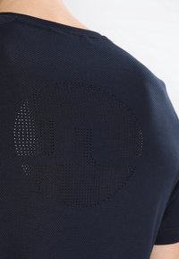 Marineblaues Sportshirt mit strukturiertem Stoff und großem, perforiertem Logodesign auf der Rückseite zur Belüftung.