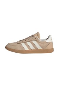Beige mockasinsneaker med vit tre-randig design och gummisula. Har rund tå, snörning fram och vadderad krage.