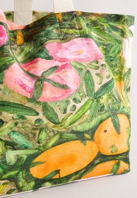 Tote taske i lærred med et livligt blomster- og citrusmønster, primært i pink og orange, med grønne accenter og robuste stofhåndtag.