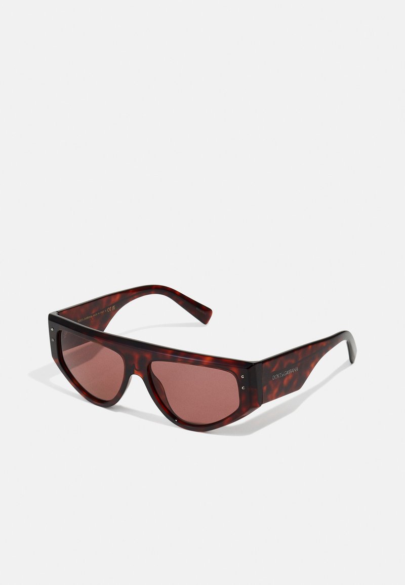 Brown tortoiseshell sunglasses with oversized rectangular lenses, tinted in red. Features metal accents on the frame and branding on the temples.