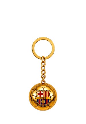 Brelok w kształcie piłki nożnej w kolorze złotym z logo FC Barcelony z czerwonymi i żółtymi paskami oraz czerwonym krzyżem na tle herbu.
