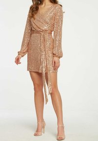 Robe portefeuille en sequins rose doré, dotée de longues manches bouffantes, d'un décolleté en V et d'une taille nouée, avec un ourlet court et une texture lisse.