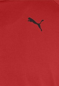 Rotes Trikot aus weichem Stoff, mit kleinem schwarzem Puma-Logo auf der linken Brust. Schlichtes Design mit Rundhalsausschnitt.