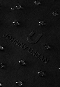 Tissu noir avec des gouttelettes d'eau perlées à la surface et le logo en relief "Johnny Urban" au centre.