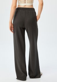 Donkergrijze wijde broek met een soepele textuur en een elastische tailleband. Het ontwerp heeft een comfortabele pasvorm van taille tot zoom.