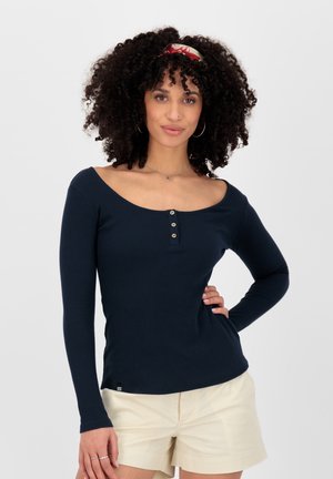 Marineblaues Langarmshirt mit weitem Ausschnitt, dreiknöpfiger Knopfleiste und figurbetontem Schnitt. Glatte Stoffoberfläche, kombiniert mit leichten Shorts.