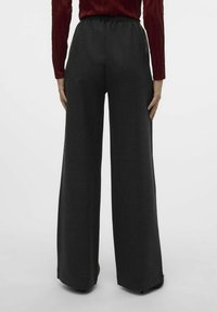 Pantalons larges en tissu charbon foncé avec une texture douce et une taille élastique, présentés de dos, arborant un design épuré.