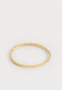 Bracciale in oro con un design a bordo ondulato e texturizzato e una fascia piatta e liscia. Il metallo ha una finitura lucida e una forma rotonda.