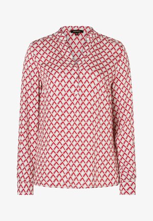 Langärmlige Bluse aus weißem Stoff mit einem geometrischen roten Muster. Auffällige Details sind der spitze Kragen und die geknöpften Manschetten.