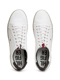 Sneaker in tela bianca con lacci piatti, fodera interna scura a contrasto e accenti a strisce rosse e blu. Presenta una suola in gomma standard.