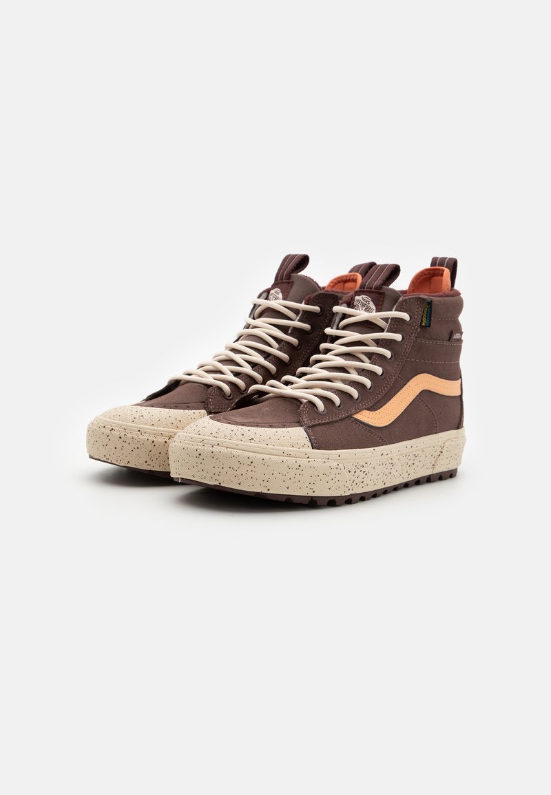 Wysokie trampki z brązowego zamszu z beżową, nakrapianą gumową podeszwą, z kremowymi sznurówkami i pomarańczowym paskiem po boku. Gumowy uchwyt na pięcie.