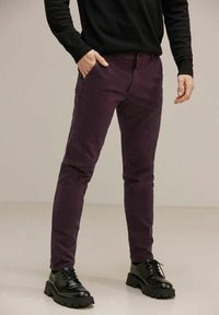 Tumman violetit slim-fit housut, jotka on valmistettu puuvillasta ja joissa on klassinen viisi-taskumalli sekä sivutaskut, yhdistettynä mustiin nauhakujiin.