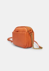 Oranžová kožená crossbody taška s texturovaným povrchem, dvojitými zipovými uzávěry a zlatým řetízkem. Kompaktní obdélníkový design.