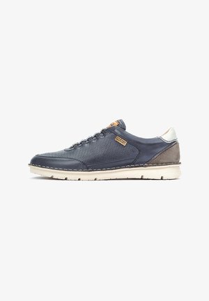 Zapatillas de deporte azul marino con parte superior de cuero y malla, acentos en gamuza gris contrastante, suela ligera y detalles cosidos a lo largo del borde.