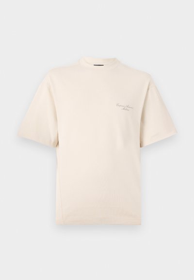 Beige tričko s krátkým rukávem a kulatým výstřihem, vyrobené z měkké bavlny. Na přední levé straně se nachází decentní výšivka.