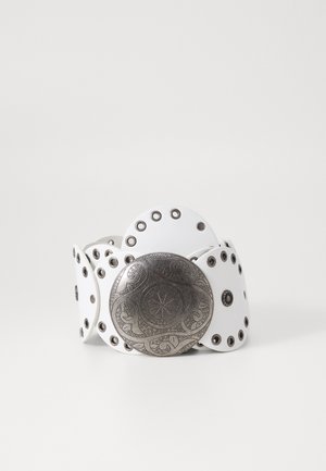 Valkoinen nahkavyö, jossa on hopeanvärinen pyöreä solki, jossa on monimutkaisia kaiverruksia, ja vyön nauhassa metalliset rei'itykset.