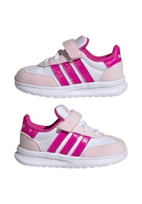 Zapatillas deportivas rosas y blancas que combinan material de ante y sintético, con una banda de velcro, tres rayas rosas y acentos en el talón texturizados.