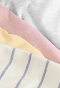 Vier stoffen stalen in zachte texturen: grijs, roze, geel en gestreept wit met lichtblauw. Elk heeft een kenmerkende, gladde afwerking.