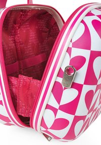 Maletín rígido en tonos rosa y blanco con un patrón de corazones, desabrochado para revelar un interior rojo con impresión de logotipo y una correa de almacenamiento.