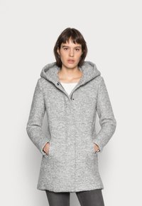 Siv obrubni plašč z teksturirano tkanino, ki ima stranske žepe, zadrgo spredaj in srednjo dolžino. Preprost in funkcionalen dizajn.