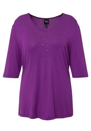 T-shirt viola a maniche corte con scollatura a V, caratterizzata da un motivo di borchie nere e metalliche vicino al collo, realizzata in tessuto morbido.
