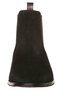 Musta virheettömästä nahan nilkkabotti, jossa on sileä pinta, pyöristetty kärki ja ommeltu sivupaneeli. Varustettu silmukkakoukulla helppoa pukemista varten.