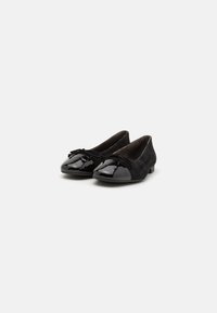 Schwarze Ballerinas aus Wildleder mit einer glänzenden Lackleder-Zehenkappe. Sie verfügen über eine Schleifendetail an der Vorderseite und einen niedrigen Absatz.