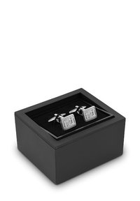 Srebrne kwadratowe spinki do mankietów z wygrawerowaną literą 'P', umieszczone w czarnym prostokątnym pudełku z miękkim wnętrzem. Pudełko ma gładkie wykończenie.