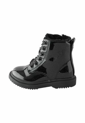 Bottine noire brillante à lacets avec semelle épaisse et doublure intérieure douce, adaptée au temps froid.