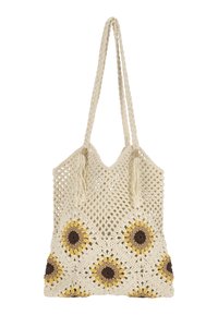 Sac fourre-tout crocheté de couleur crème avec des tournesols jaunes et bruns. Il possède des anses tressées et des pompons. Design ouvert avec un tissu texturé.