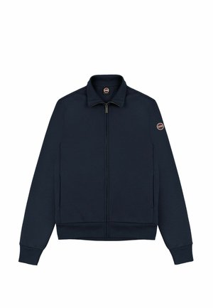 Jachetă bleu marin cu fermoar, fabricată dintr-un material moale, cu guler înălțat, manșete ribificate și un patch cu logo pe brațul stâng.