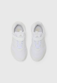 Baskets blanches avec tige en maille et synthétique, dotées d'une sangle Velcro, de lacets et d'un branding doré subtil sur la languette.